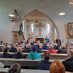 Viele Menschen sitzen in der Kirche von Seddin und hören Frau Lüdke zu