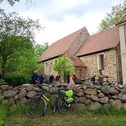 Mehrere Fahrräder stehen vor der Kirche von Seddin an der Feldsteinmauer